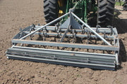 Rear view of Red River Arenas Buster 2.0 arena drag grooming footing in a roping arena with heavy-duty S-tines and paddle wheel crumbler