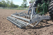 Side view of Buster 2.0 arena groomer attached to tractor in horse arena