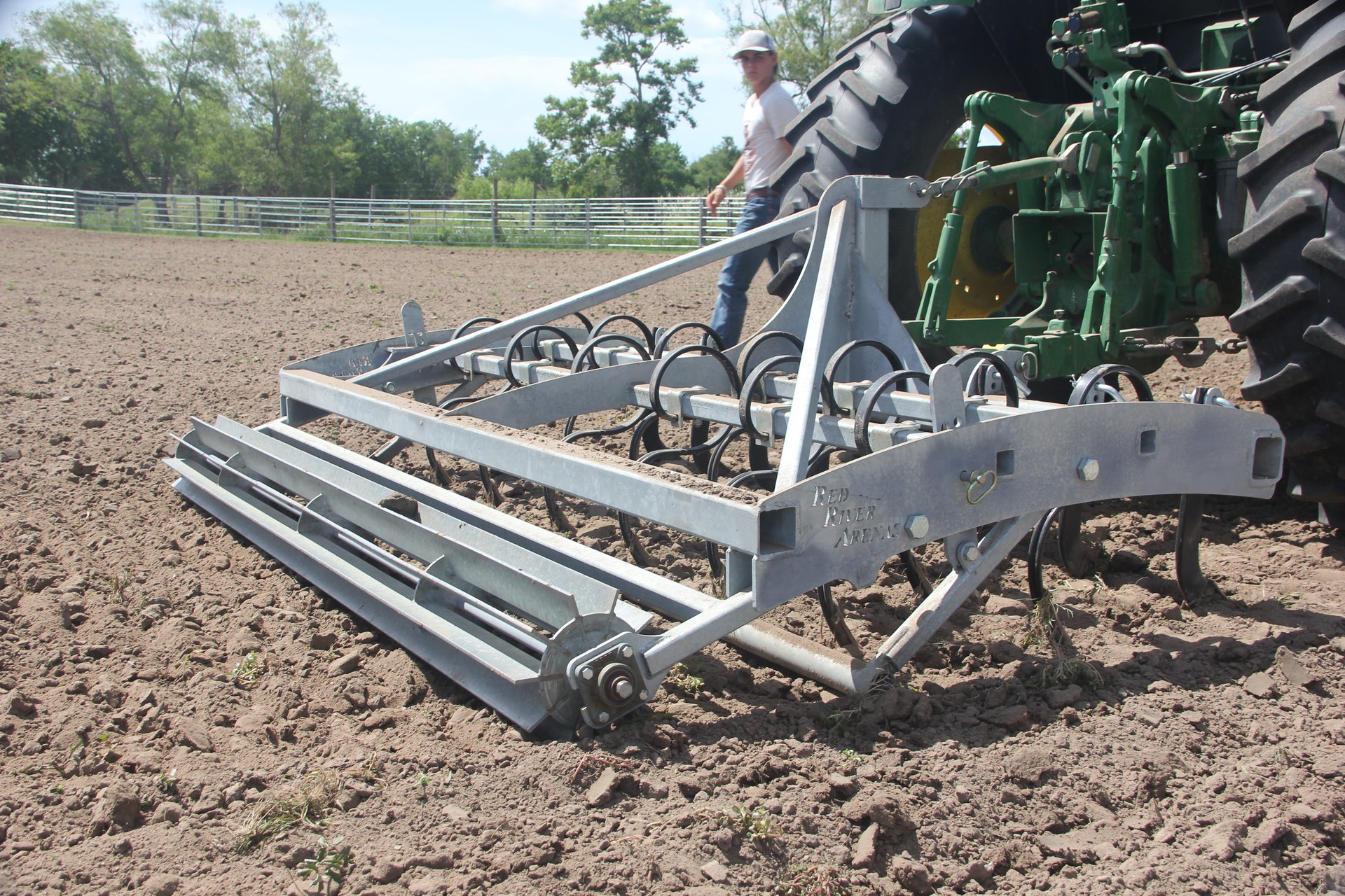 Side view of Buster 2.0 arena groomer attached to tractor in horse arena